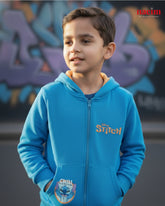 Child wearing a blue hoodie with 'Stitch' design in front of a graffiti wall.