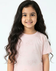 Young girl with long, wavy hair wearing a light pink shirt on a white background