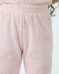 Pink pajama pants with bunny patterns on a light background