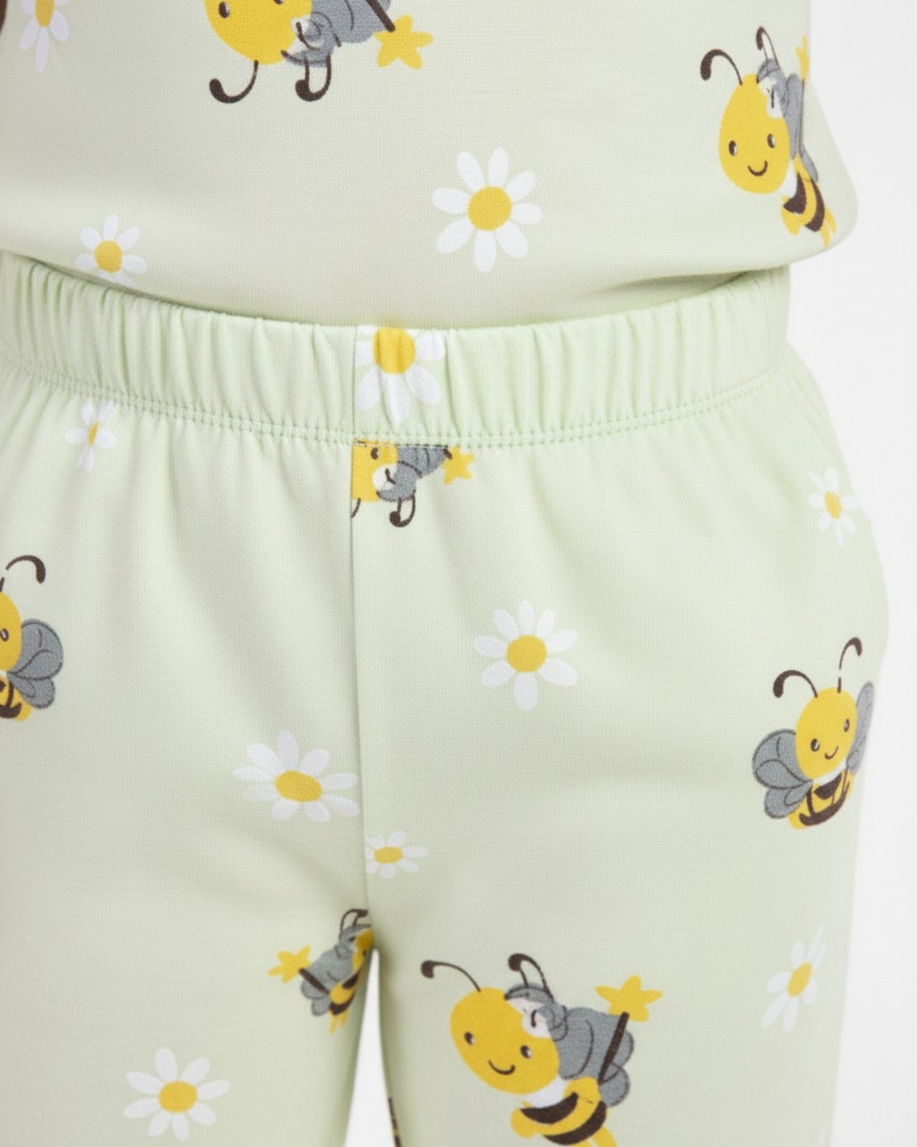 Children's outfit with bee and flower pattern on a light green background