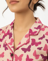 Close-up of a pink butterfly patterned shirt worn by a person.
