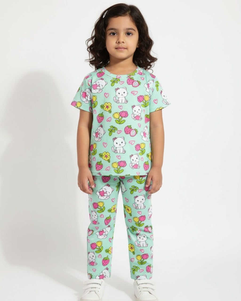 Child wearing a light blue pajama set with cartoon characters and flowers on a white background