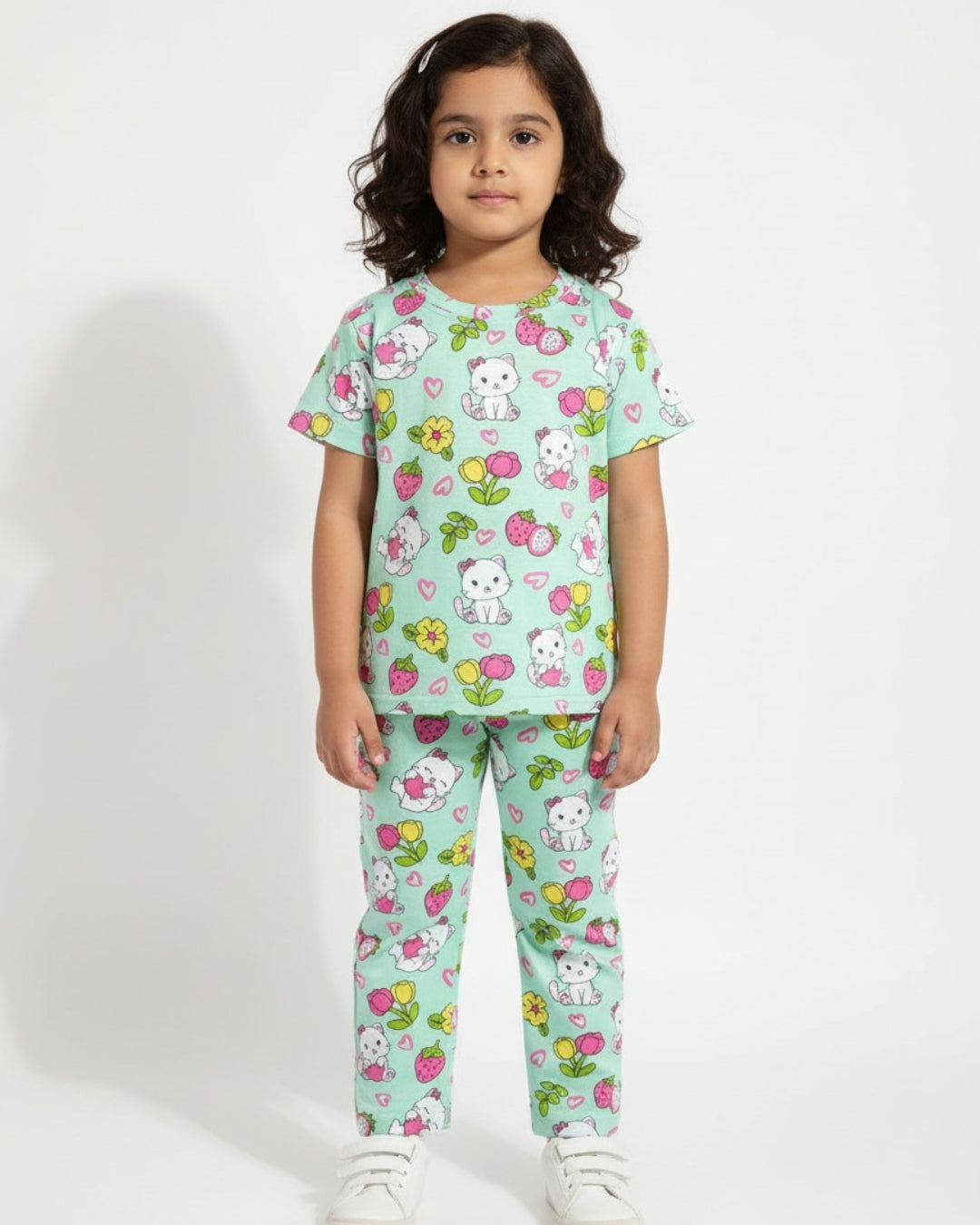 Child wearing a light blue pajama set with cartoon characters and flowers on a white background