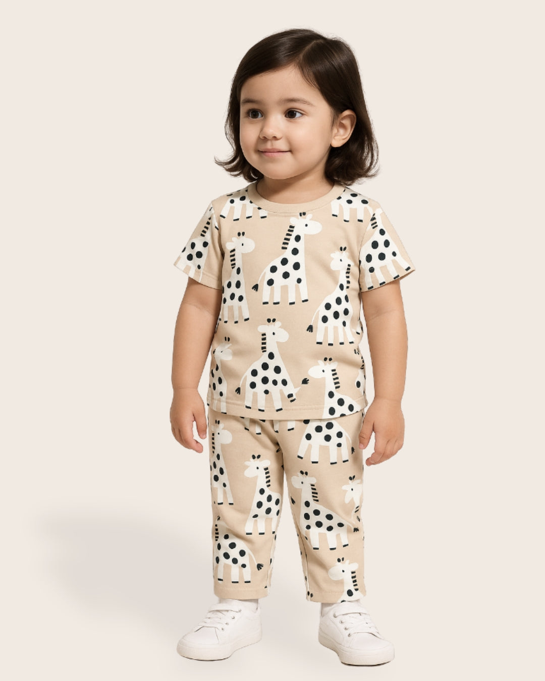 Child wearing a beige outfit with black and white animal prints on a plain background