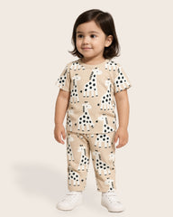 Child wearing a beige outfit with black and white animal prints on a plain background
