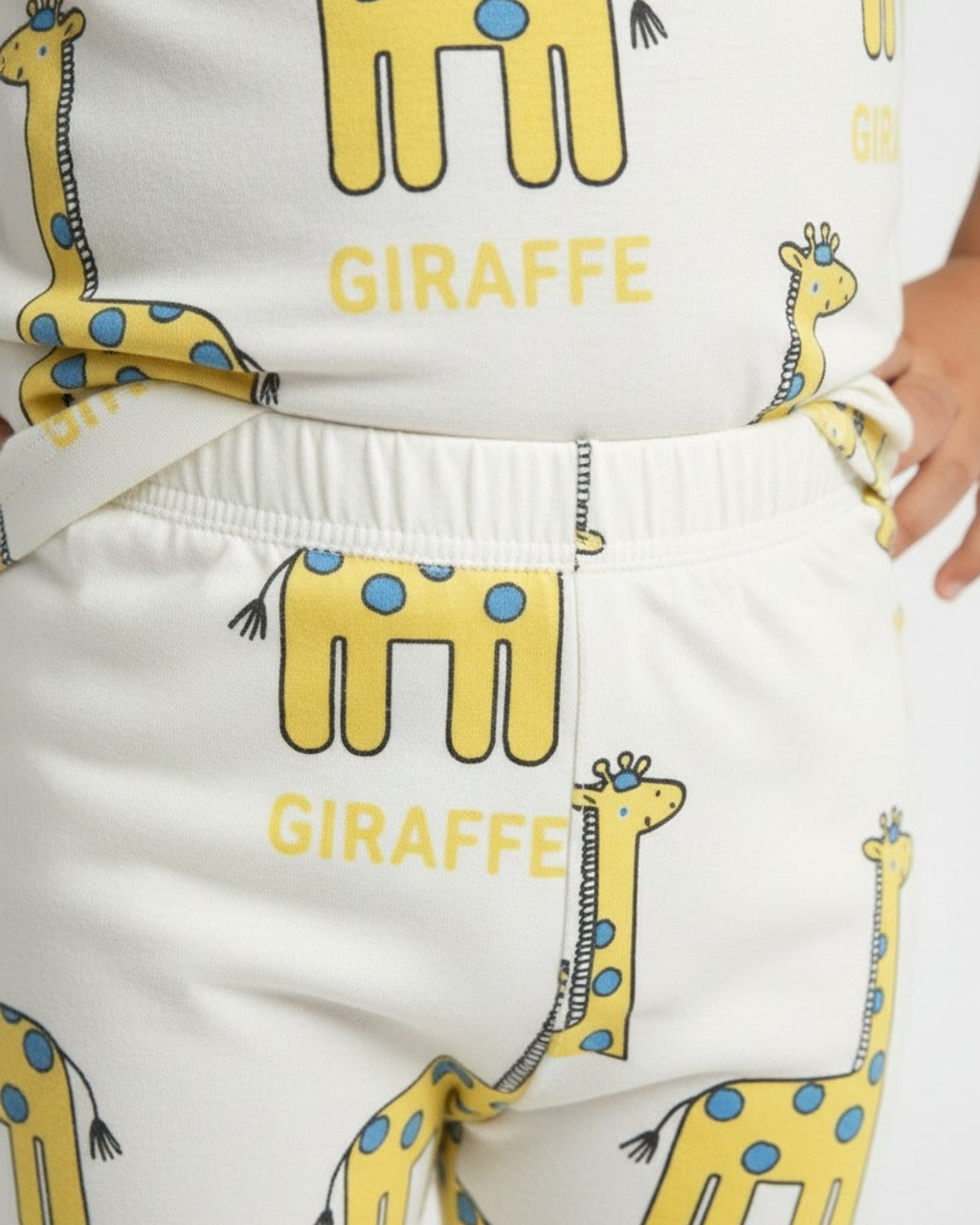 White pants with yellow giraffe illustrations and 'GIRAFFE' text on a white background