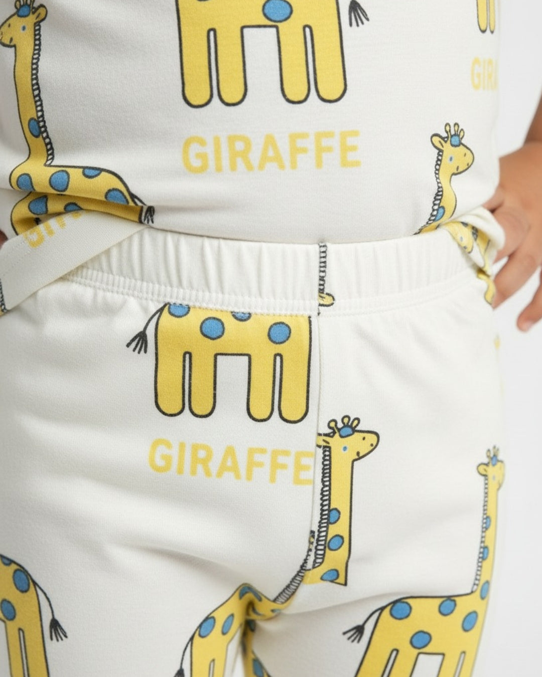 White pants with yellow giraffe illustrations and 'GIRAFFE' text on a white background