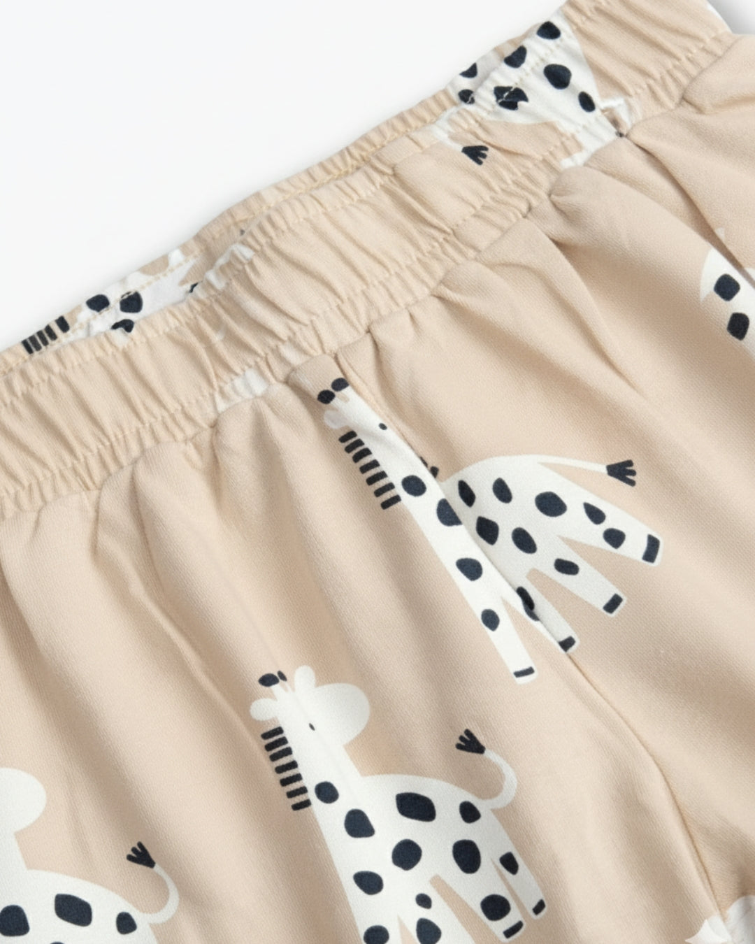 Beige shorts with black and white giraffe prints on a white background