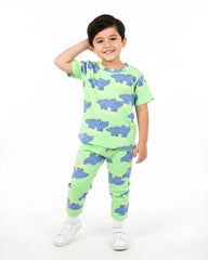 Child wearing a green pajama set with blue crocodile patterns on a white background