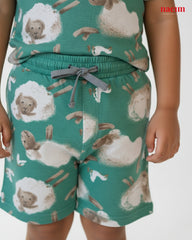 Child's outfit with animal-patterned shorts and top on a plain background