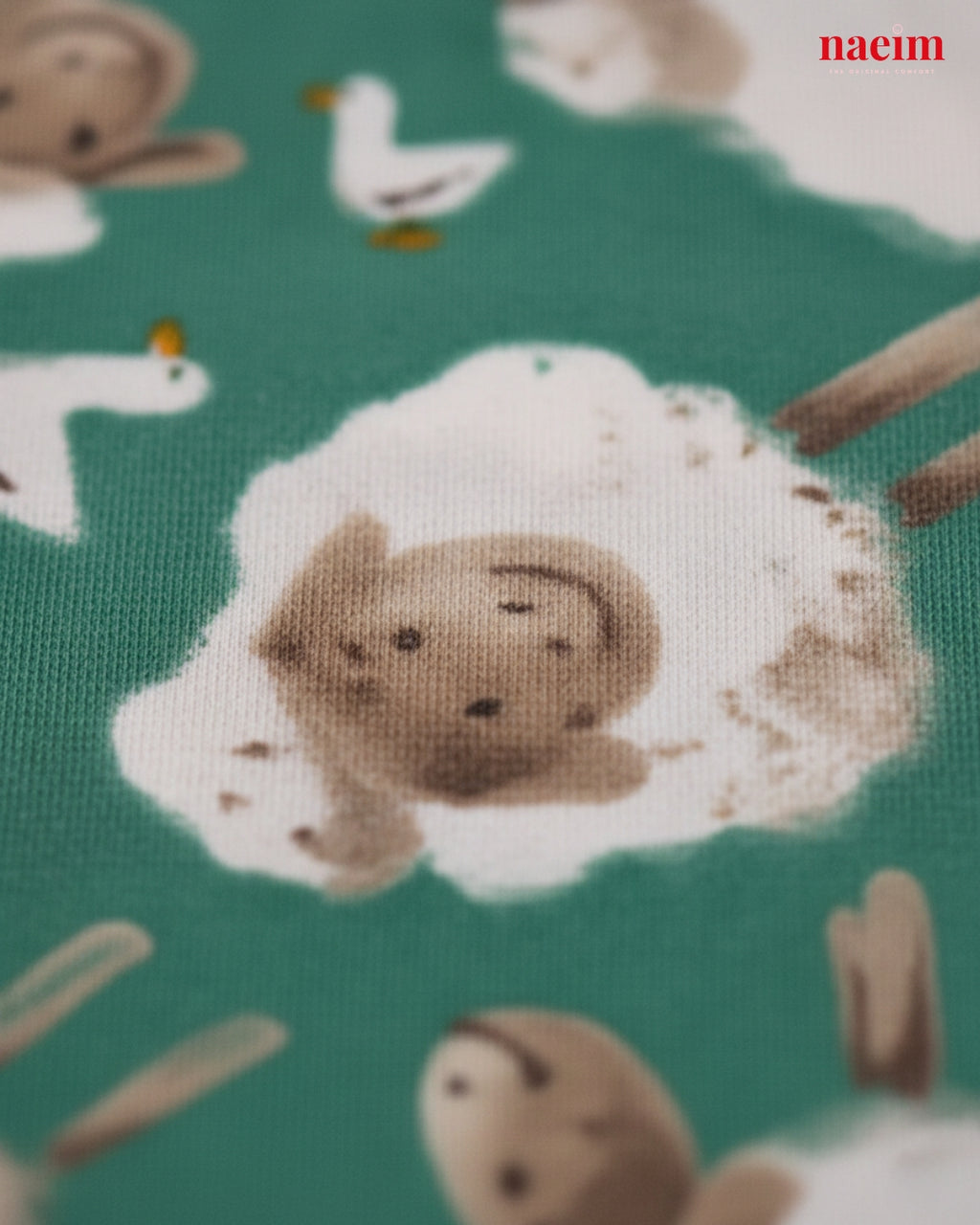 Fabric with animal pattern including bears, birds, and sheep on a green background.