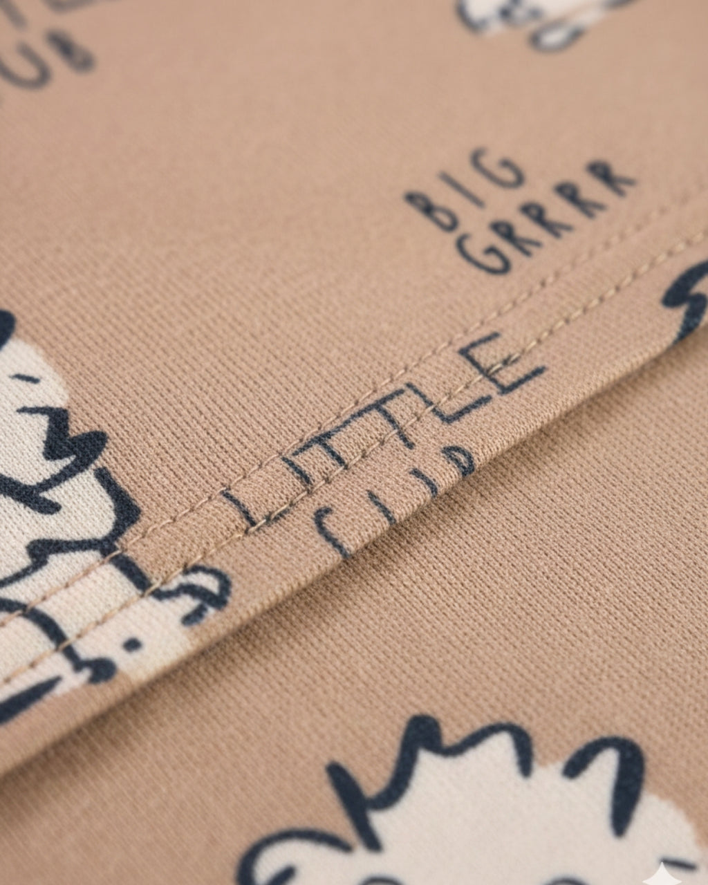 Text on fabric with cartoon characters, including 'BIG GRRR' and 'LITTLE CUB'.