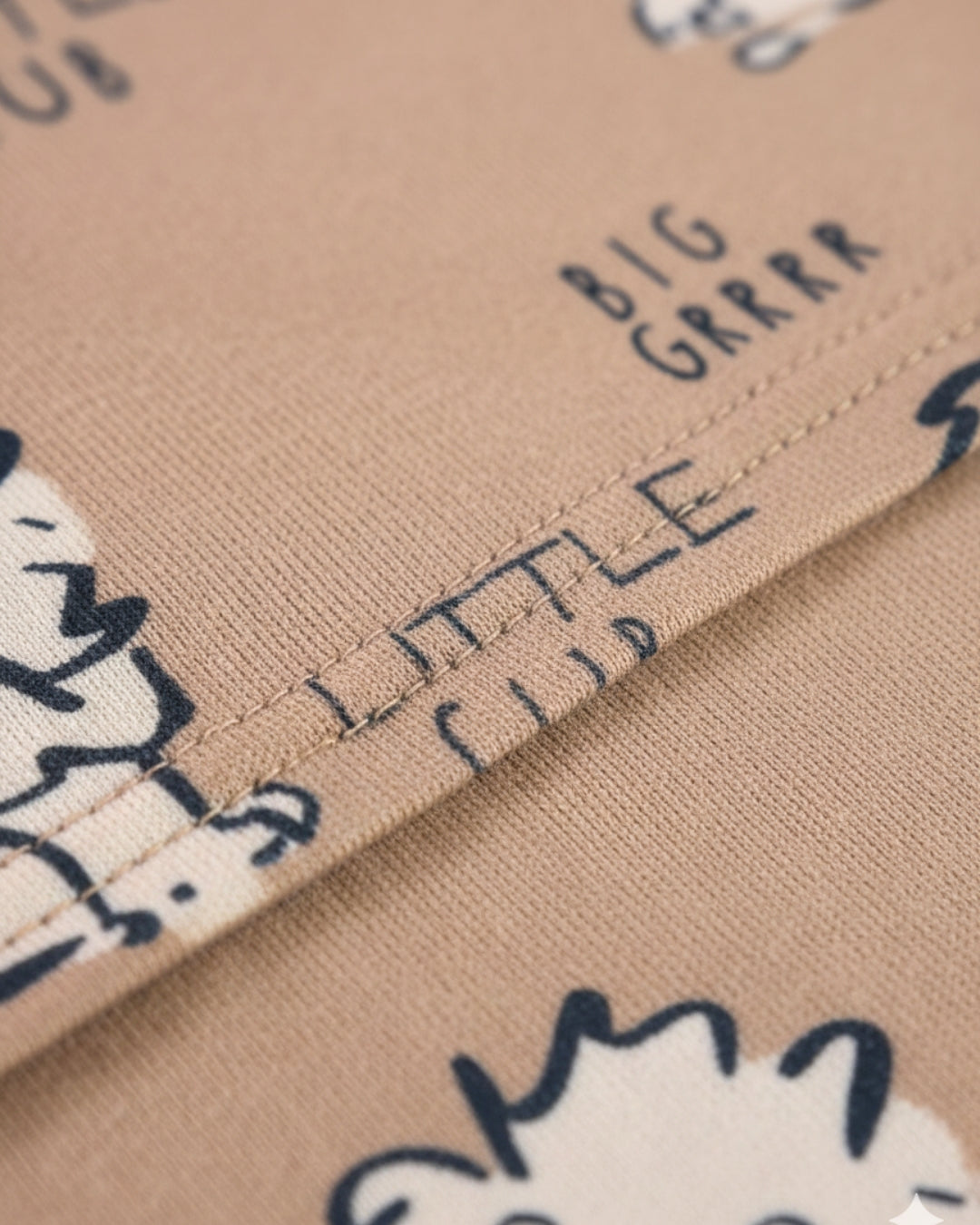 Text on fabric with cartoon characters, including 'BIG GRRR' and 'LITTLE CUB'.