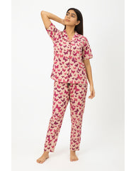 Woman wearing a pink butterfly pattern pajama set on a white background