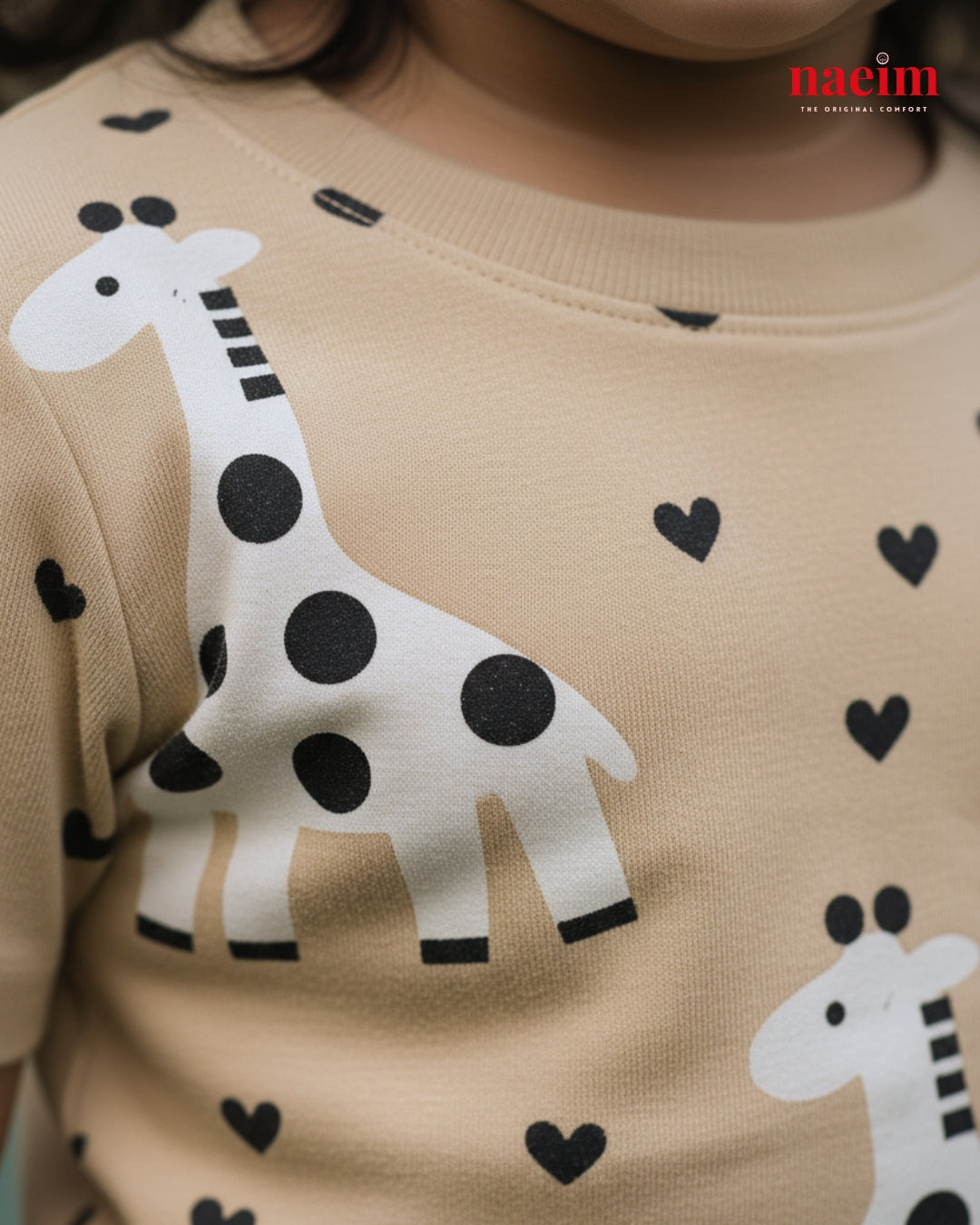 Children's shirt with giraffe and heart patterns on a beige background