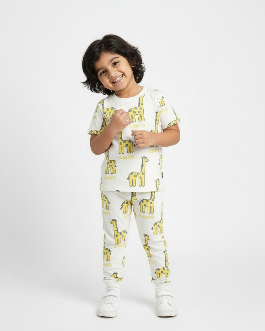 Child wearing a white pajama set with yellow giraffe prints on a white background