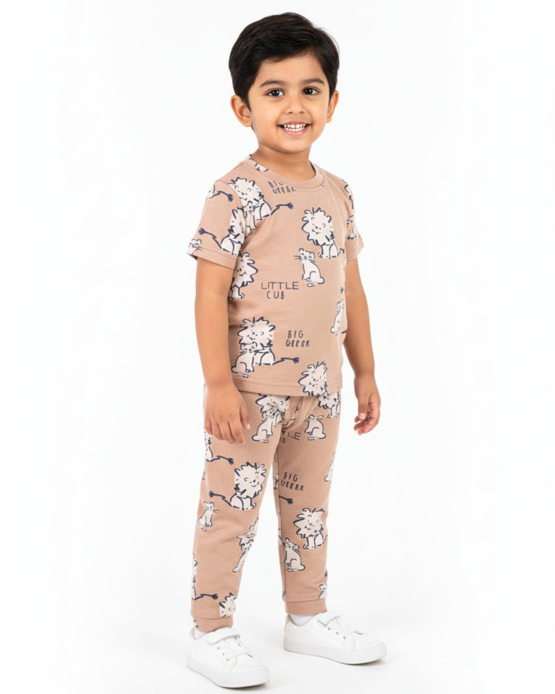 Child wearing a beige outfit with white dog prints on a white background