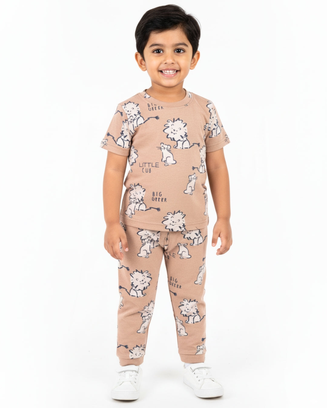 Child wearing a beige pajama set with animal prints on a white background