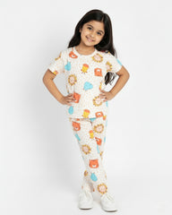 Young girl wearing a colorful pajama set with animal prints on a white background
