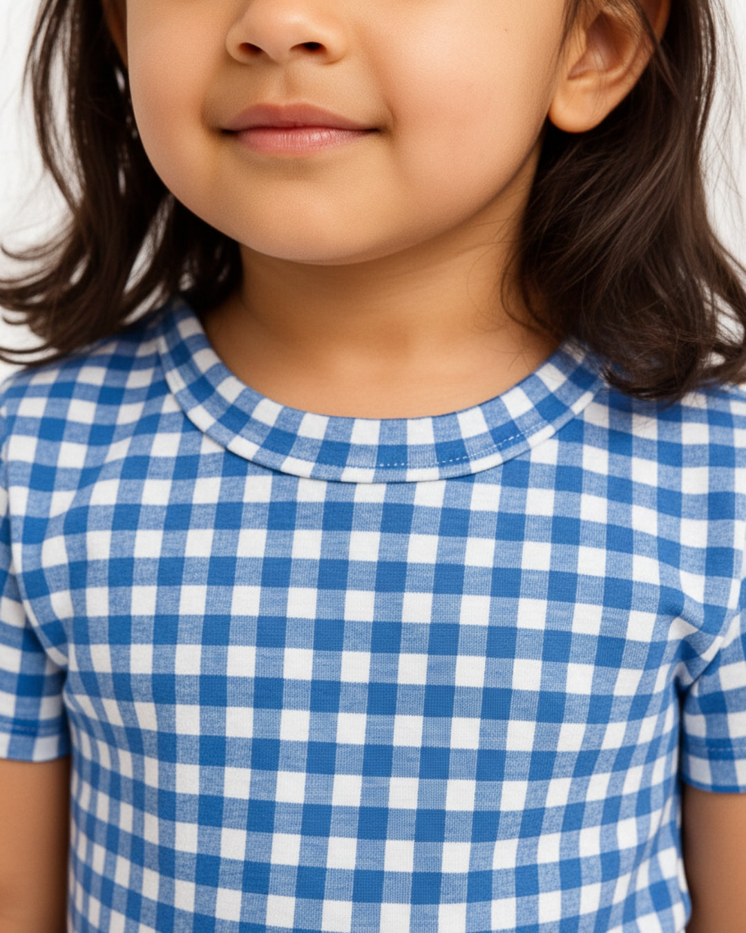 Close-up of a child wearing a blue and white checkered shirt
