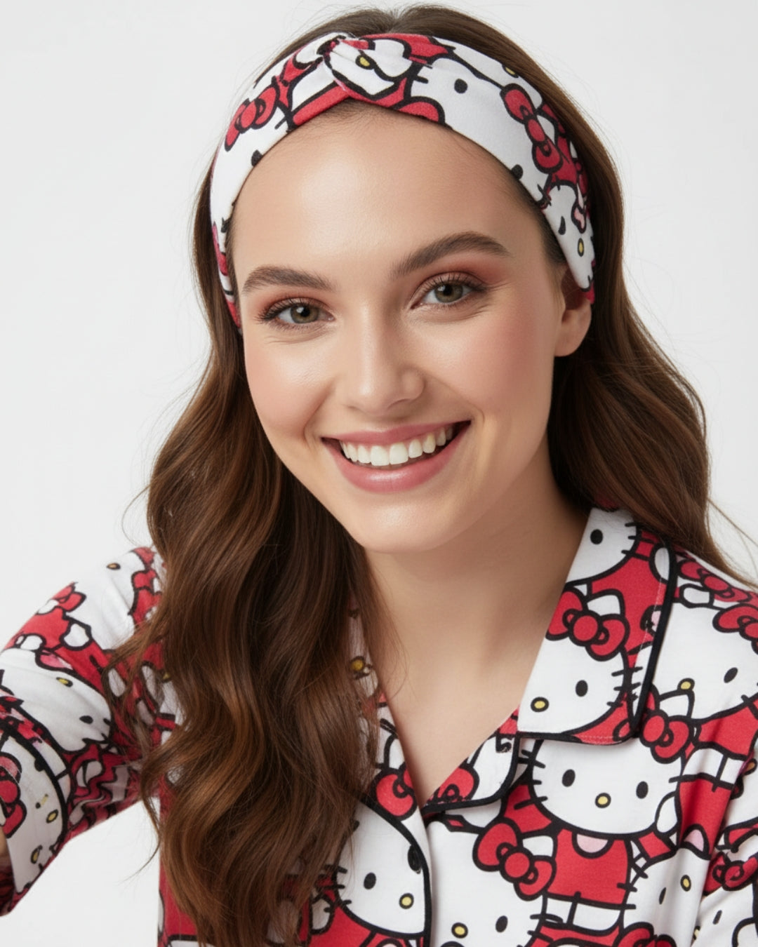 Woman wearing a Hello Kitty headband and pajama set on a white background
