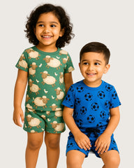 Two children wearing pajamas with sheep and soccer ball patterns on a plain background