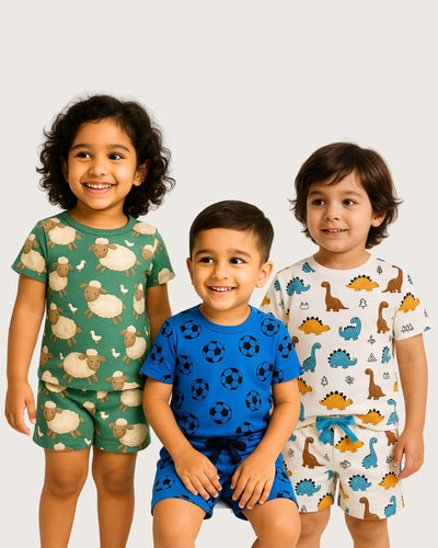 Three children wearing patterned pajamas on a plain background