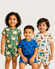 Three children wearing patterned pajamas on a plain background