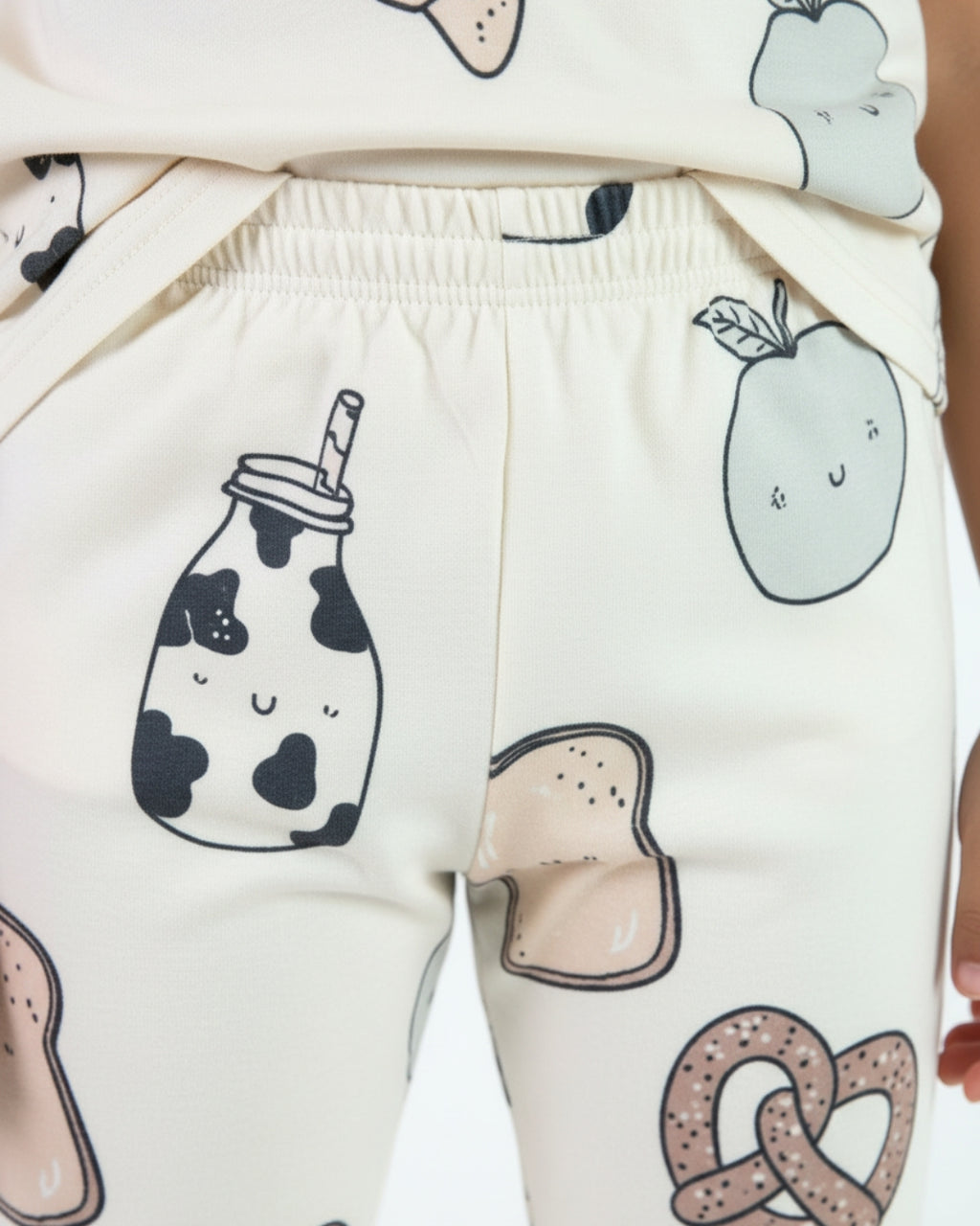 Children's pants with cartoonish food illustrations on a white background