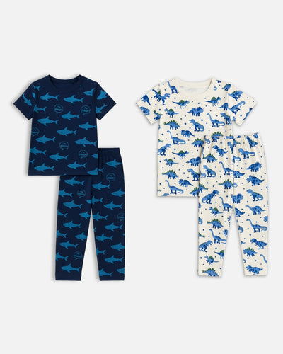 Two sets of children's pajamas with shark and dinosaur patterns on a white background.