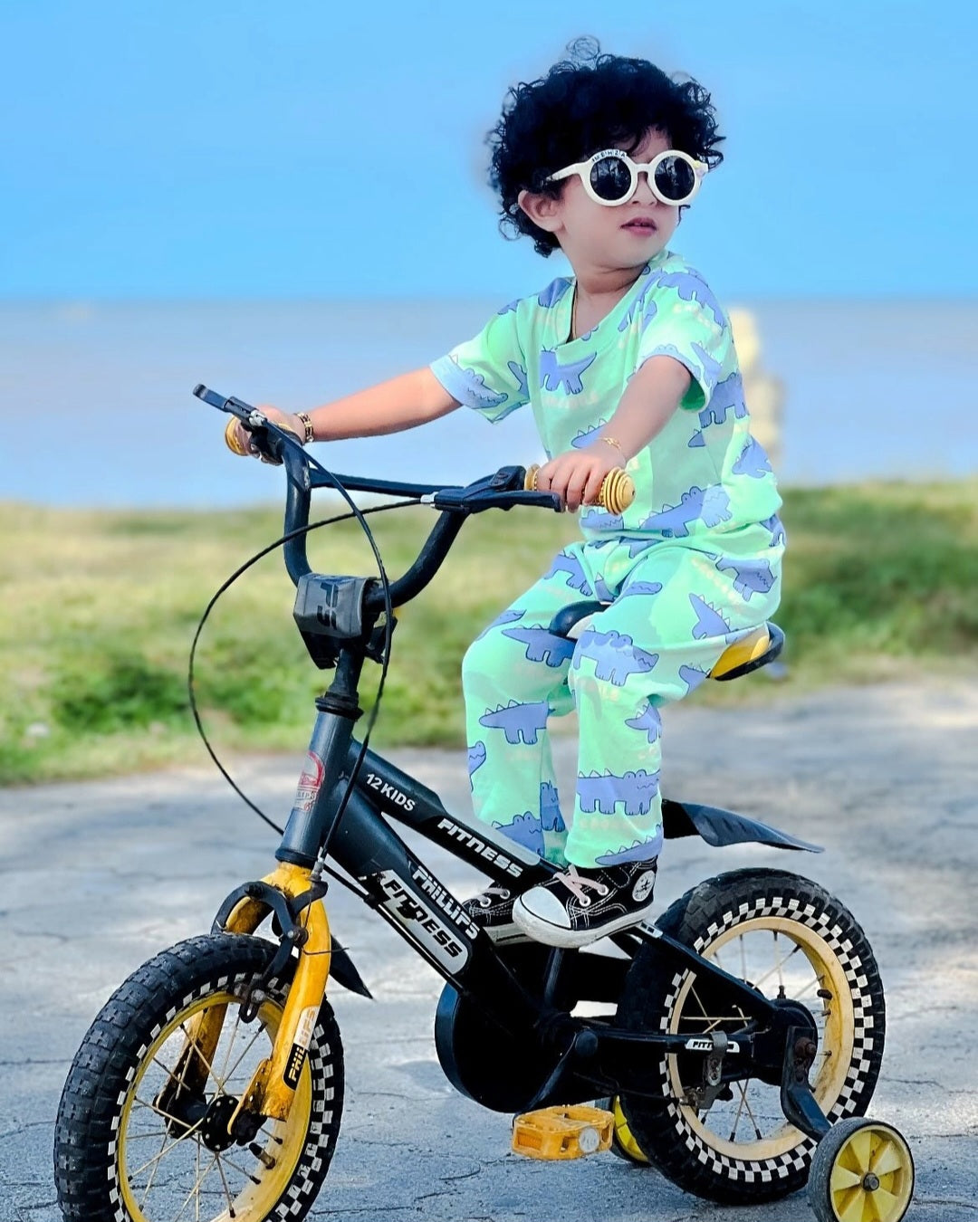 Child riding a bicycle outdoors with a clear sky background
